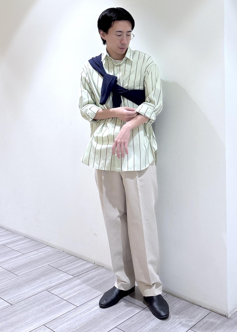 ブルー系のニット/セーター、グリーン系のシャツ/ブラウス、ベージュ系のスラックスを着用したメンズの冬コーディネートの2枚目の写真