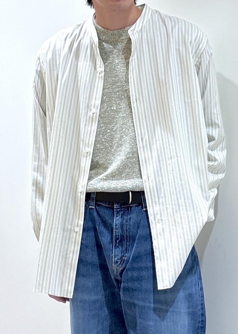 ブルー系のデニムパンツ、イエロー系のニット/セーター、ホワイト系のシャツ/ブラウスを着用したメンズの冬コーディネートの2枚目の写真