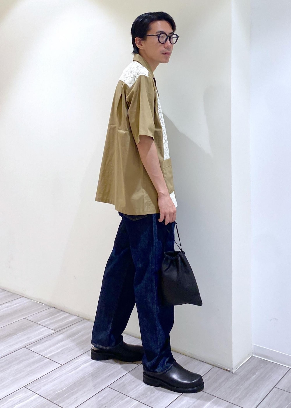 ベージュ系のTシャツ/カットソー、ブルー系のデニムパンツを着用したメンズの夏コーディネートの2枚目の写真