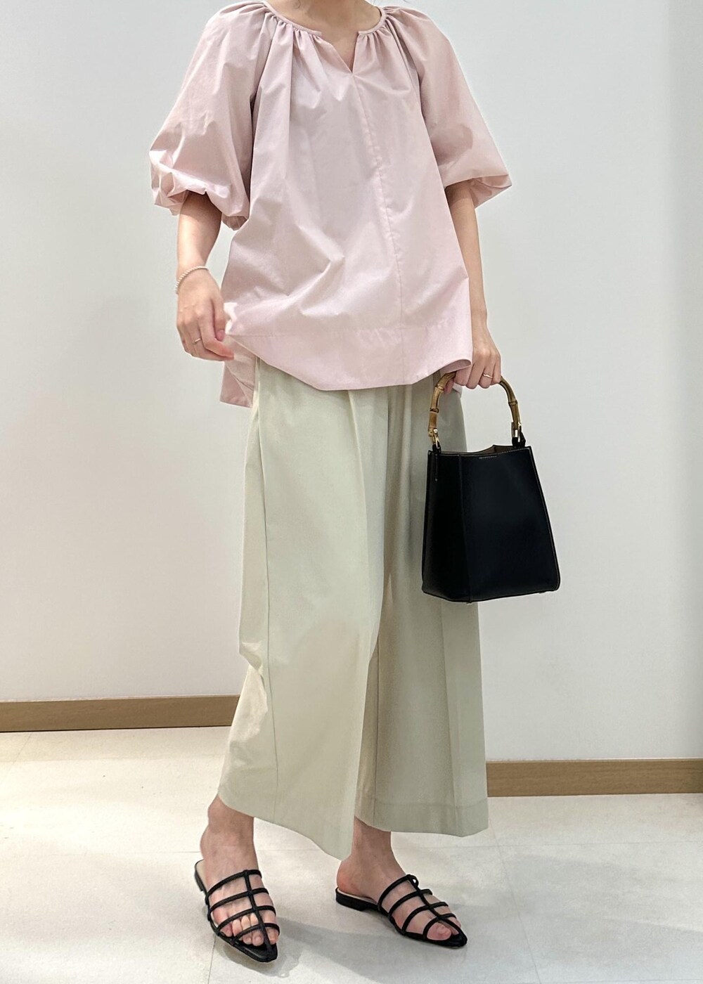 ベージュ系のその他パンツ、ピンク系のシャツ/ブラウス、ブラック系のハンドバッグを着用したレディースの夏コーディネートの5枚目の写真