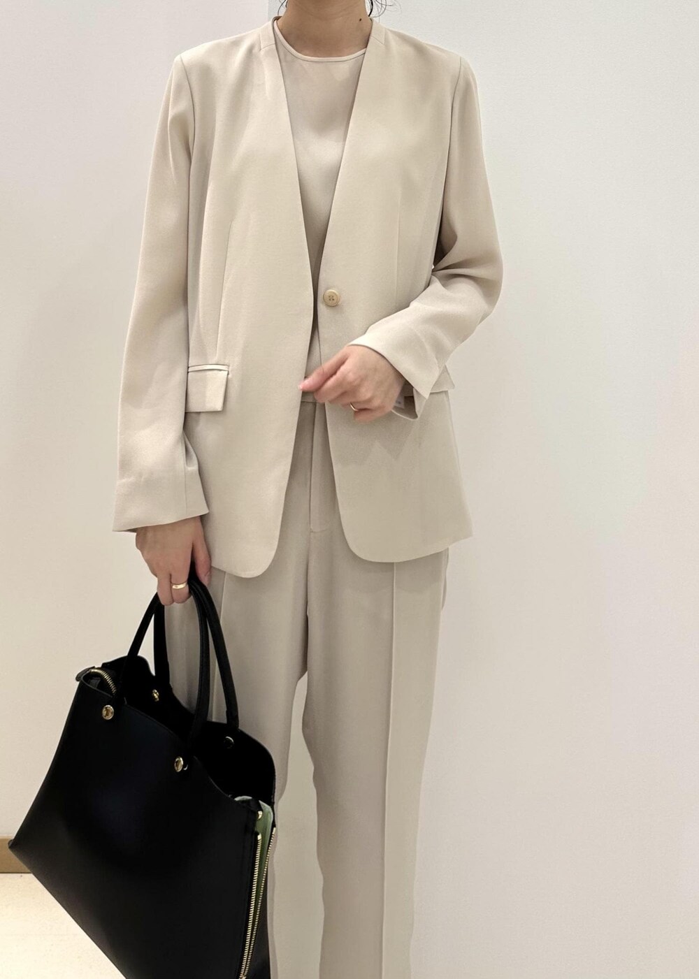 ブラック系のハンドバッグ、ブラック系のサンダル、ベージュ系のシャツ/ブラウスを着用したレディースの夏コーディネートの5枚目の写真