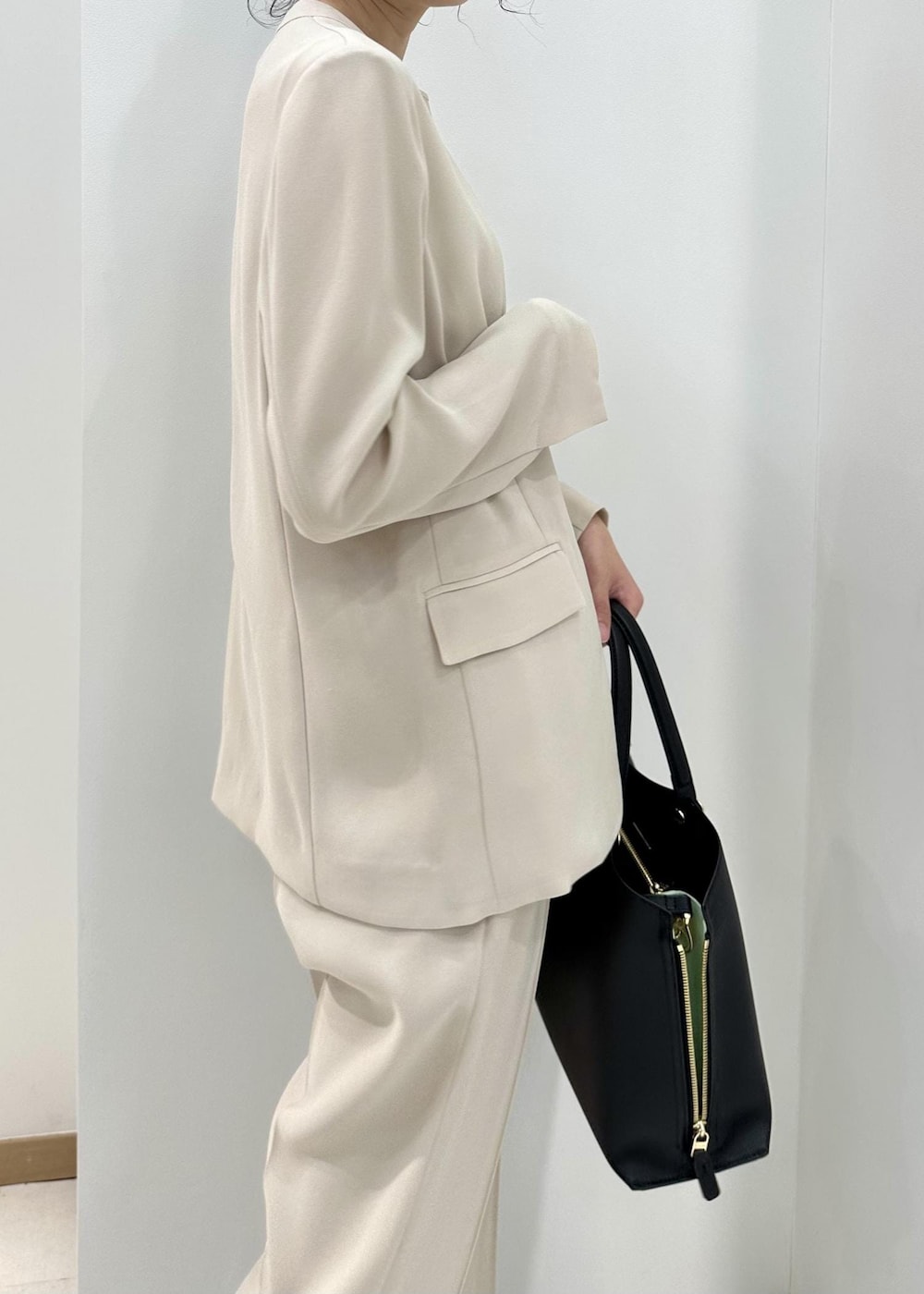 ブラック系のハンドバッグ、ブラック系のサンダル、ベージュ系のシャツ/ブラウスを着用したレディースの夏コーディネートの8枚目の写真