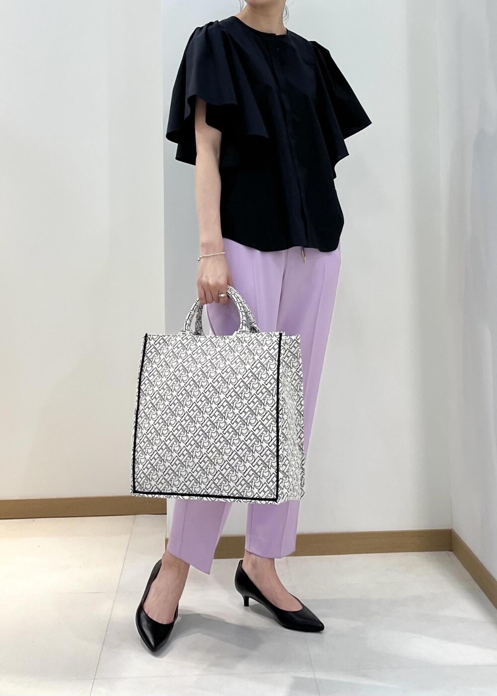 ブラック系のパンプス、ブラック系のトートバッグ、パープル系のその他パンツを着用したレディースの春コーディネートの5枚目の写真