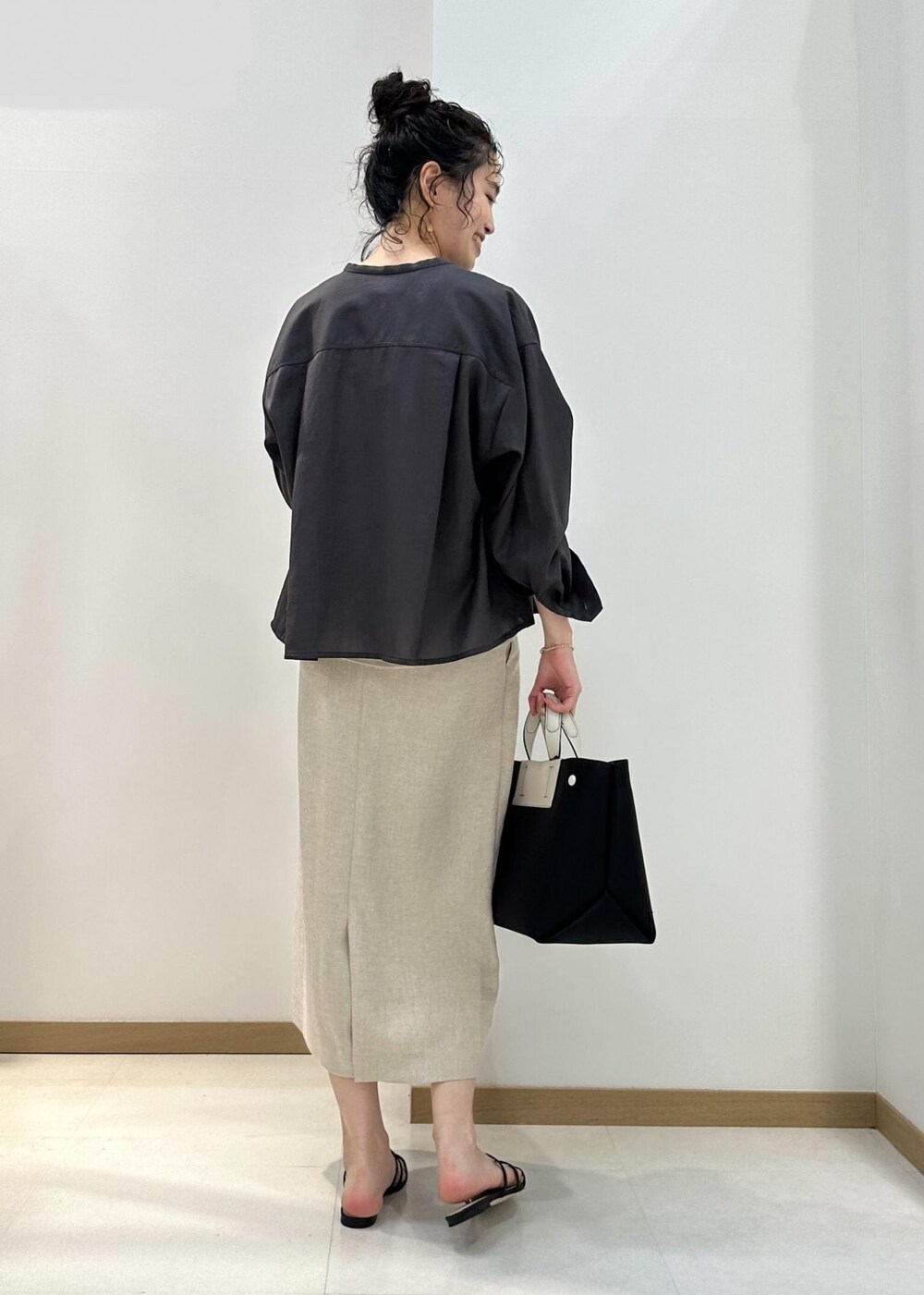 ブラウン系のシャツ/ブラウス、ベージュ系のシャツ/ブラウス、ブラック系のハンドバッグを着用したレディースの夏コーディネートの3枚目の写真