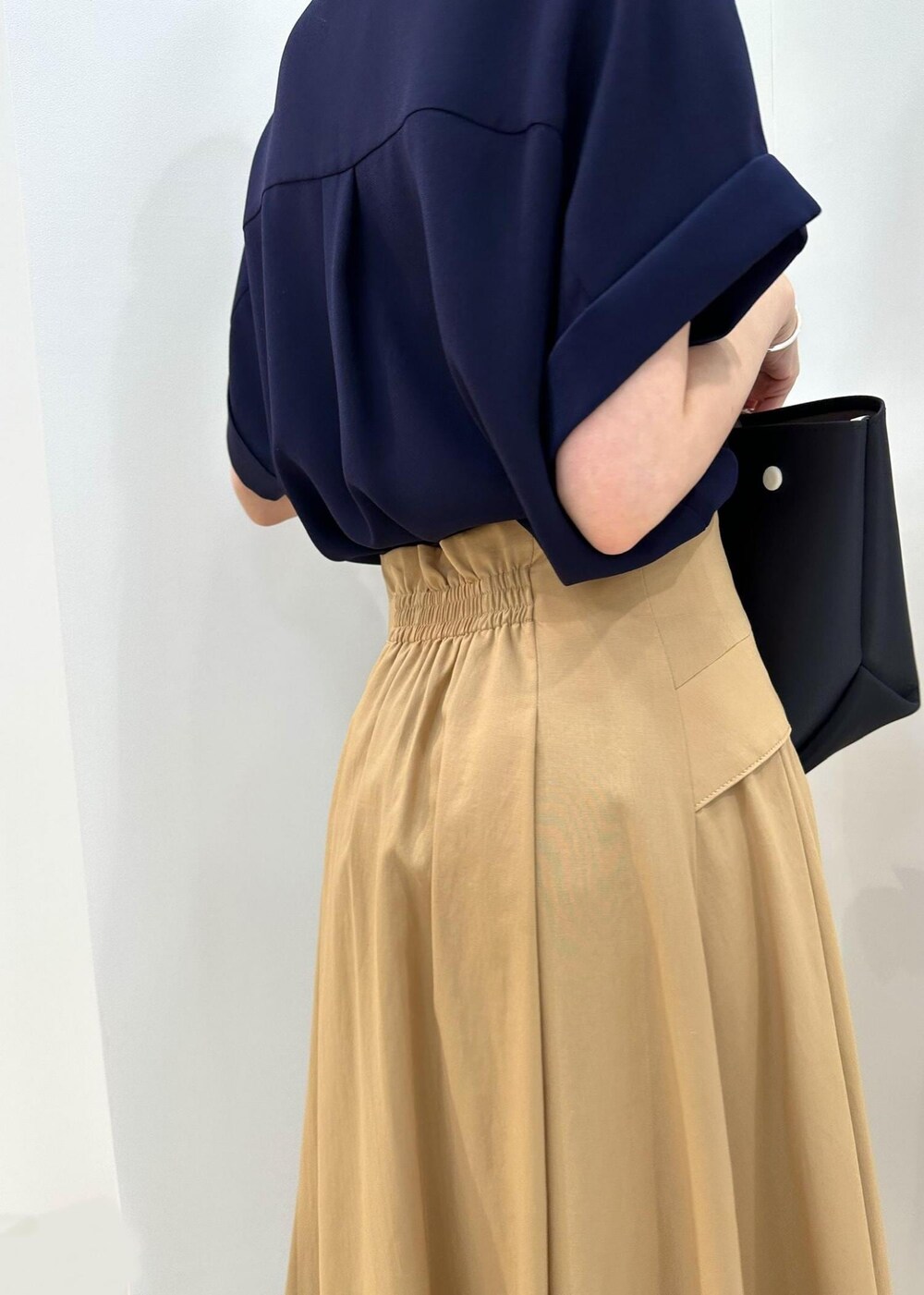 ブラック系のハンドバッグ、ブラック系のレインシューズ、ブルー系のシャツ/ブラウスを着用したレディースの夏コーディネートの7枚目の写真