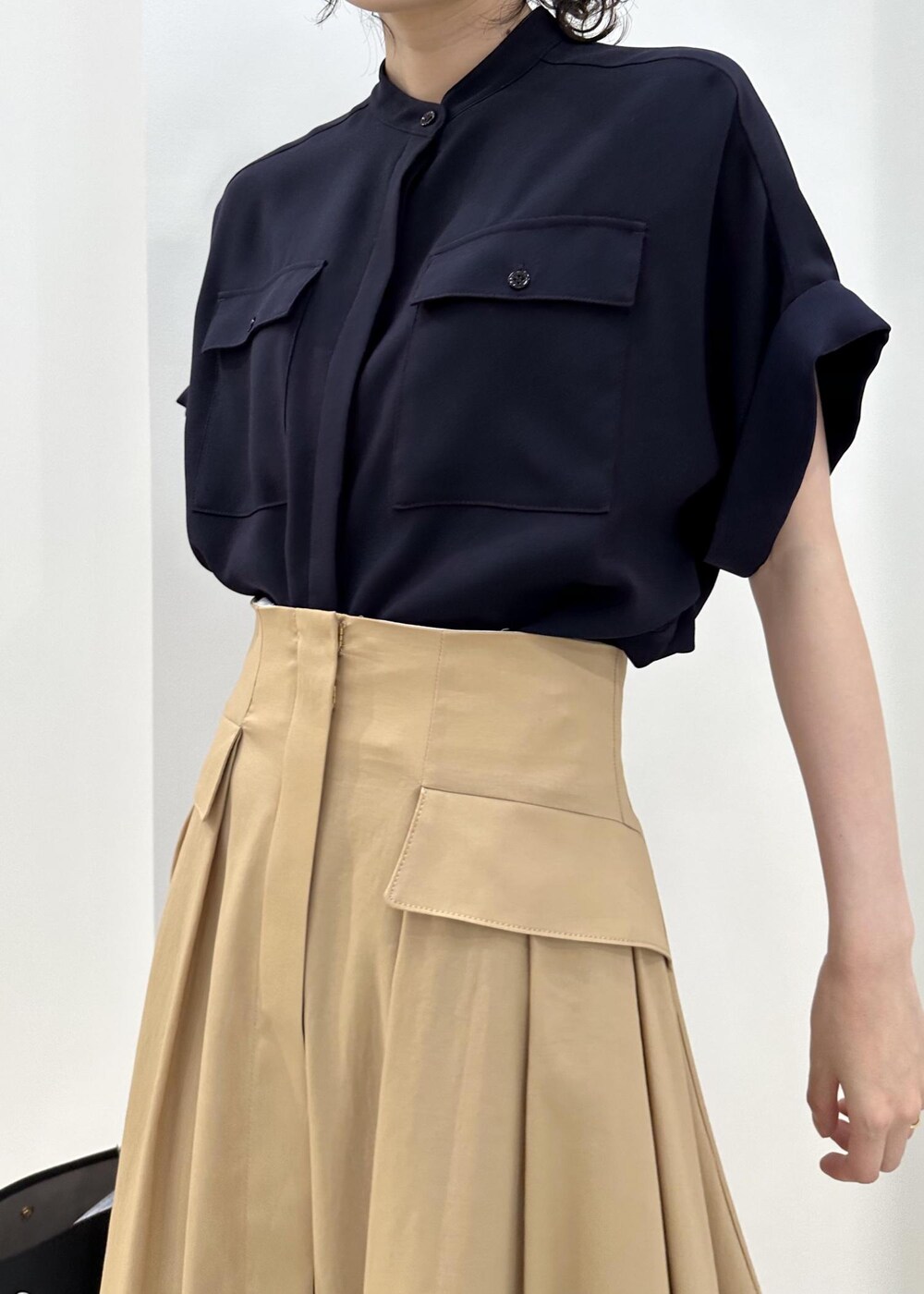 ブラック系のハンドバッグ、ブラック系のレインシューズ、ブルー系のシャツ/ブラウスを着用したレディースの夏コーディネートの6枚目の写真