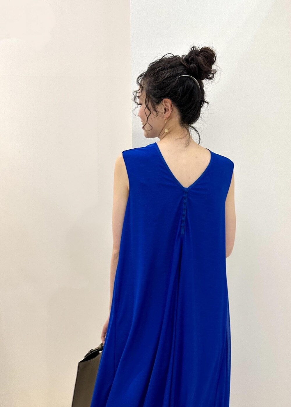 ブラック系のトートバッグ、ブルー系のサンダル、ブルー系のワンピースを着用したレディースの春コーディネートの8枚目の写真