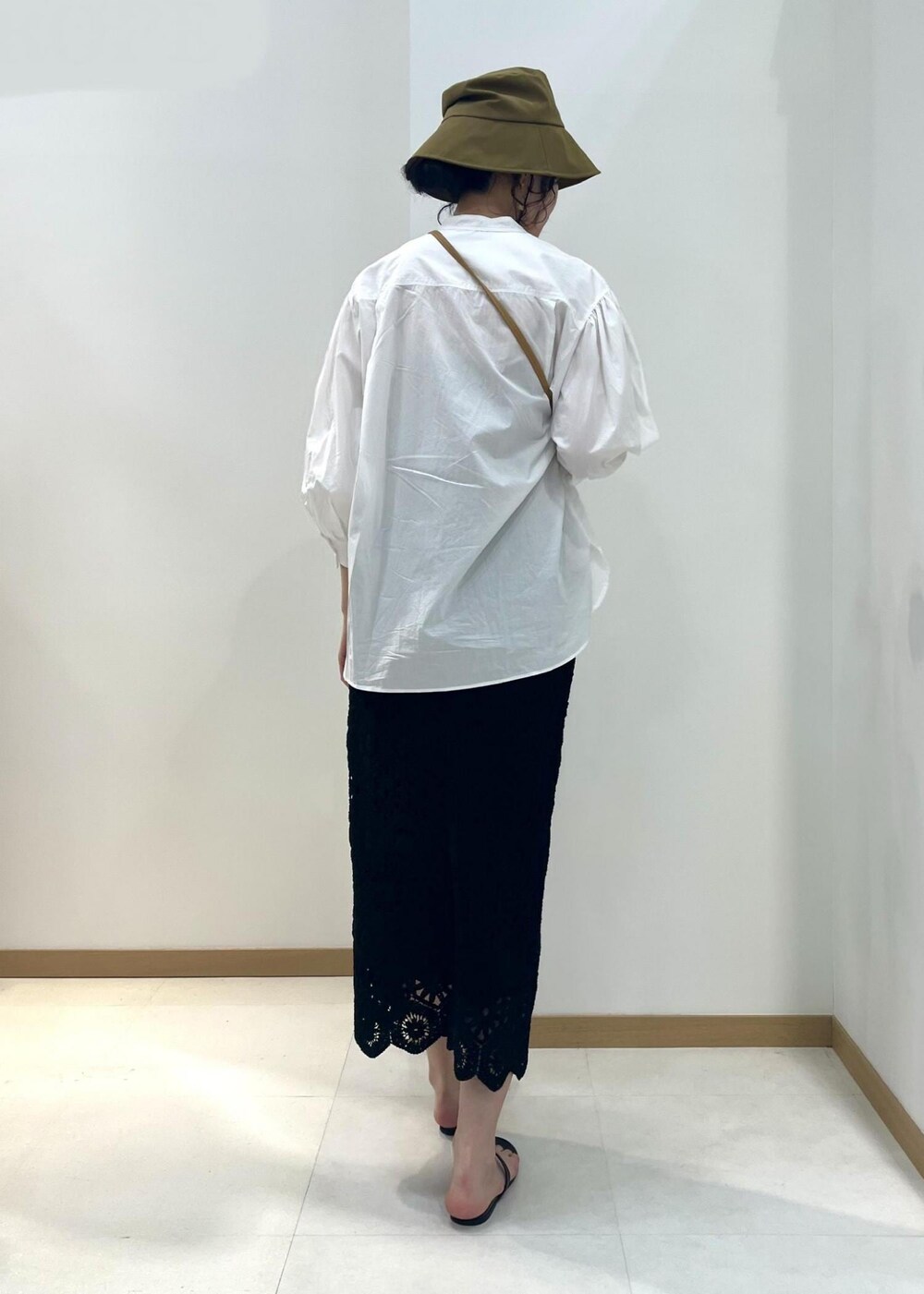 ホワイト系のシャツ/ブラウス、ブラック系のスカート、ベージュ系のハンドバッグを着用したレディースの春コーディネートの3枚目の写真