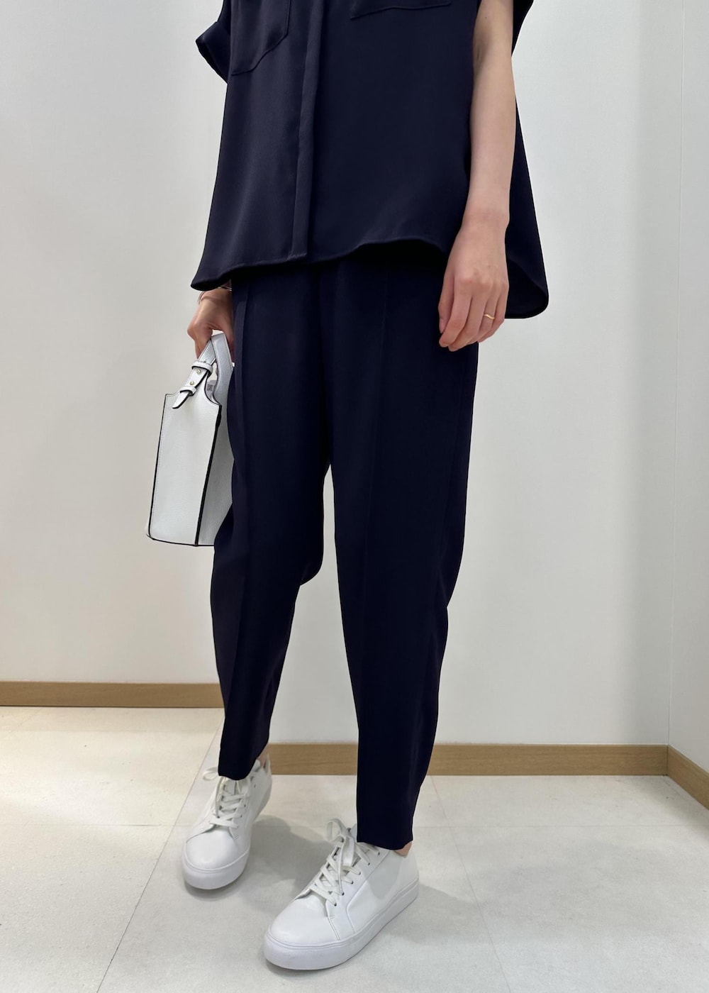 ホワイト系のハンドバッグ、ホワイト系のスニーカー、ブルー系のその他パンツを着用したレディースの夏コーディネートの5枚目の写真