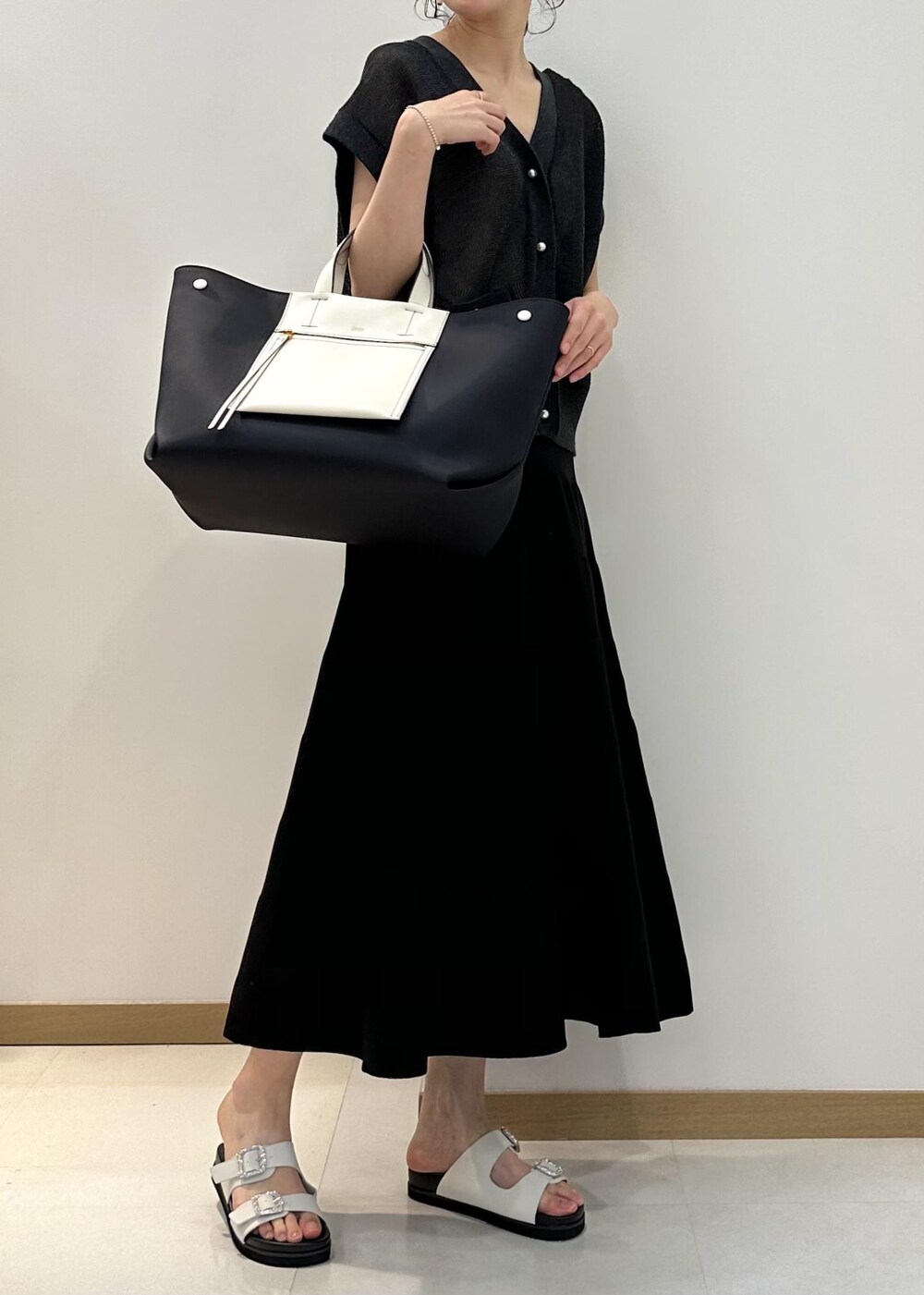 ブラック系のハンドバッグ、ホワイト系のサンダル、ブラック系のスカートを着用したレディースの夏コーディネートの4枚目の写真