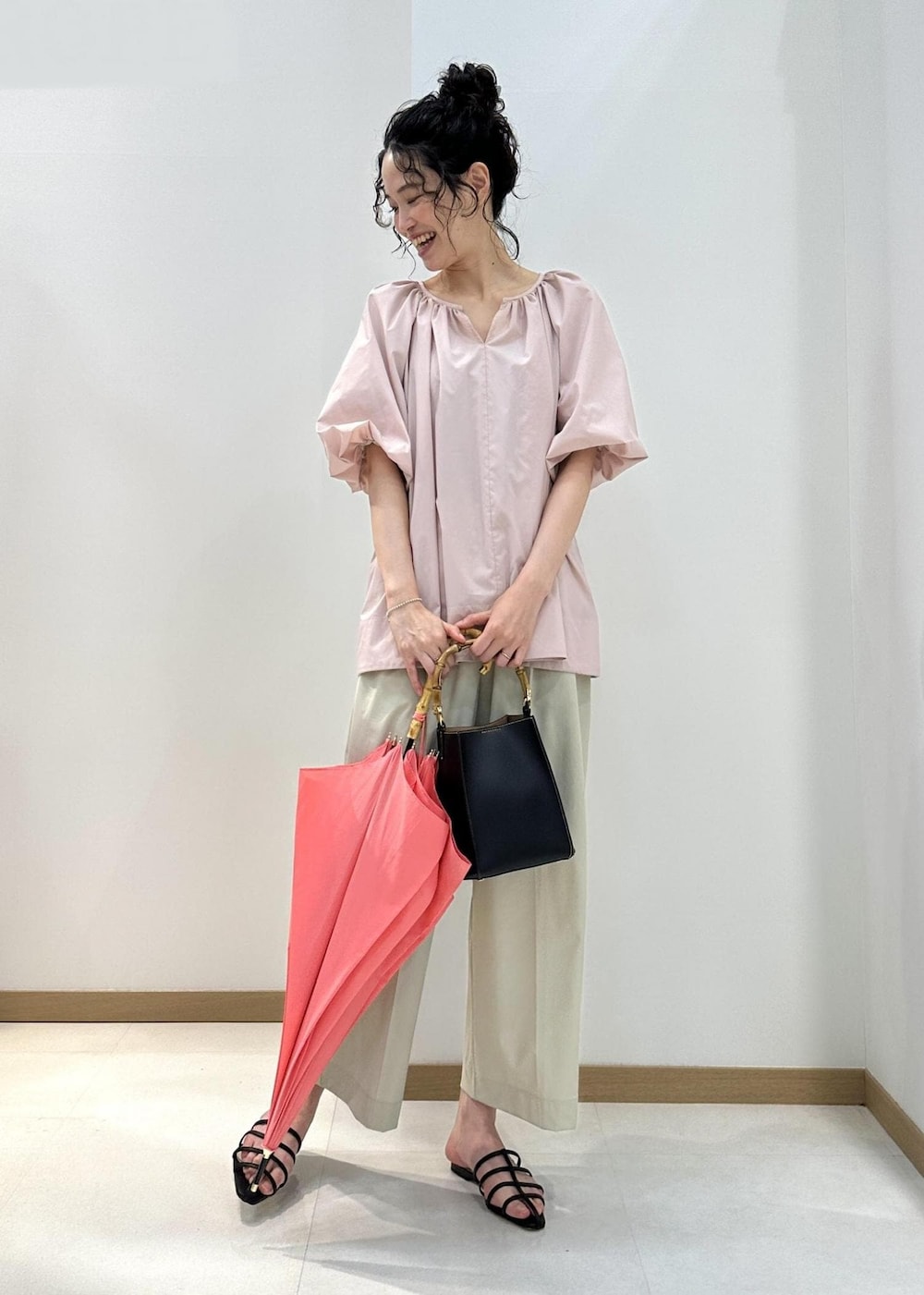 ベージュ系のその他パンツ、ピンク系のシャツ/ブラウス、ブラック系のハンドバッグを着用したレディースの夏コーディネートの2枚目の写真