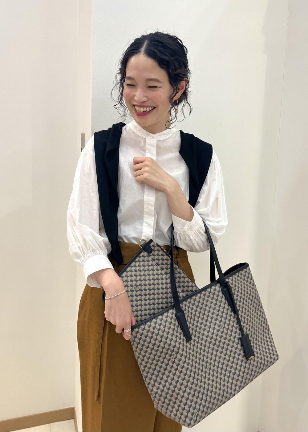 ブラック系のパンプス、ホワイト系のシャツ/ブラウス、ブラック系のカーディガン/ボレロを着用したレディースの春コーディネートの5枚目の写真