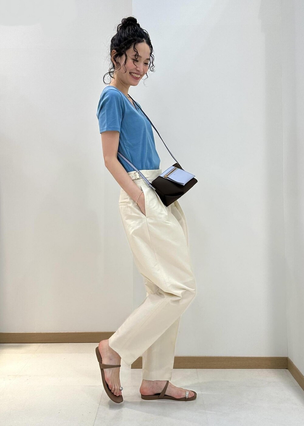 ブラウン系のショルダーバッグ、ベージュ系のサンダル、ホワイト系のその他パンツを着用したレディースの夏コーディネートの2枚目の写真