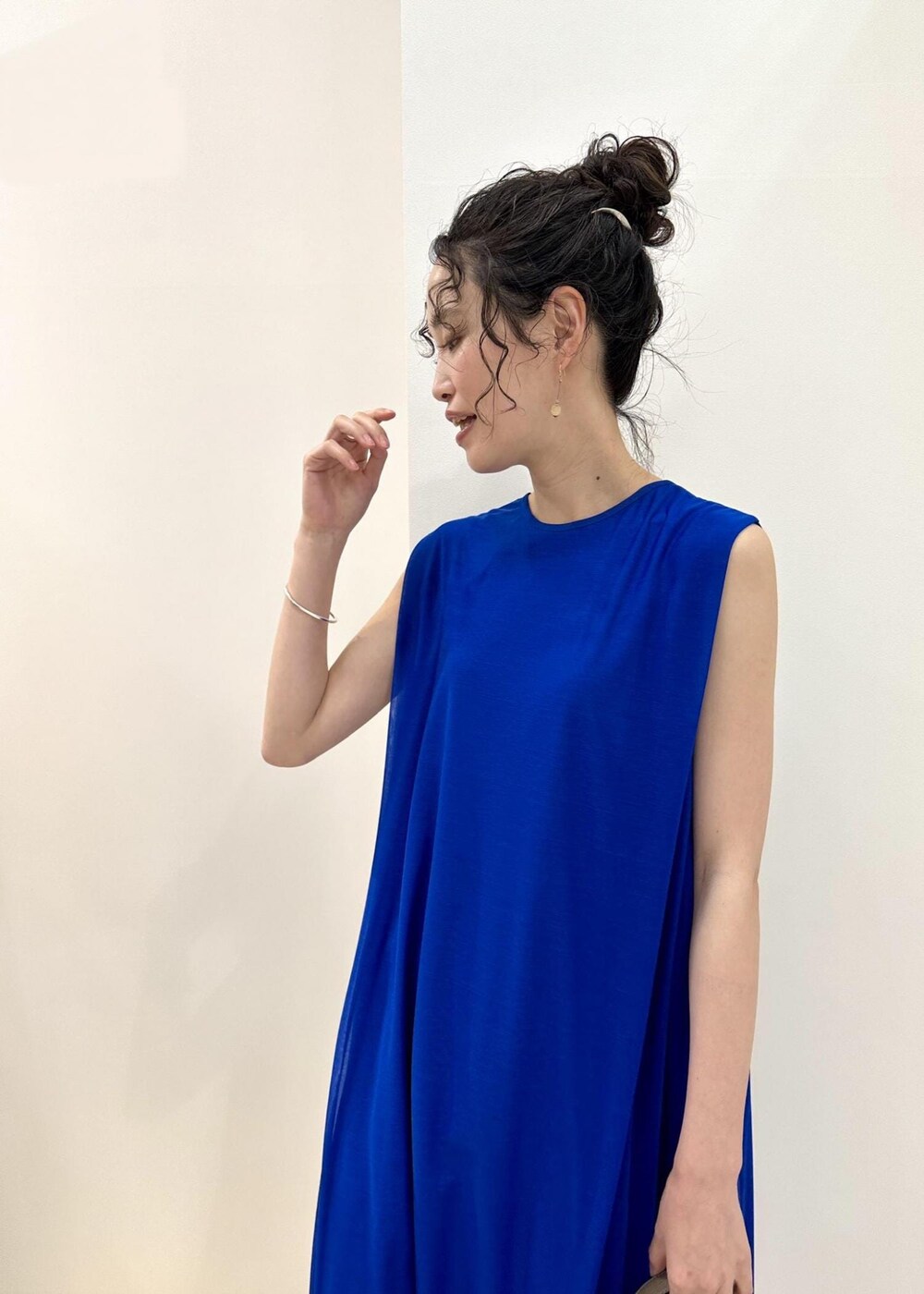 ブラック系のトートバッグ、ブルー系のサンダル、ブルー系のワンピースを着用したレディースの春コーディネートの7枚目の写真