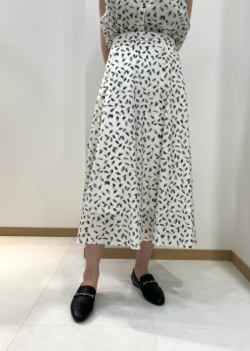 ブラック系のトートバッグ、ブラック系のレインシューズ、ホワイト系のシャツ/ブラウスを着用したレディースの春コーディネートの5枚目の写真