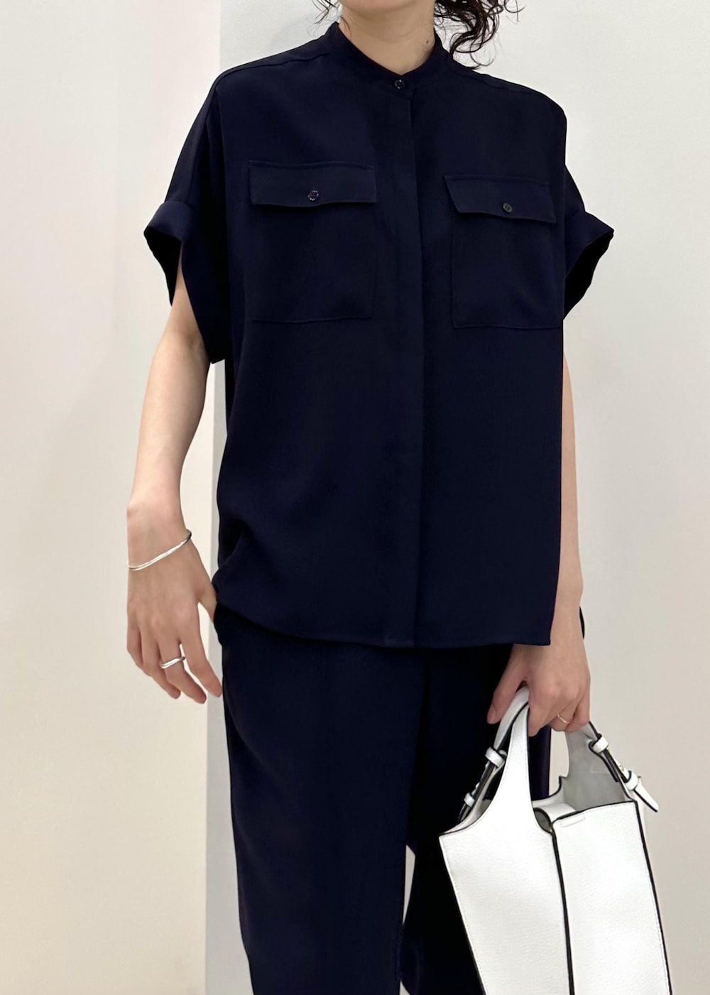 ホワイト系のハンドバッグ、ホワイト系のスニーカー、ブルー系のその他パンツを着用したレディースの夏コーディネートの6枚目の写真