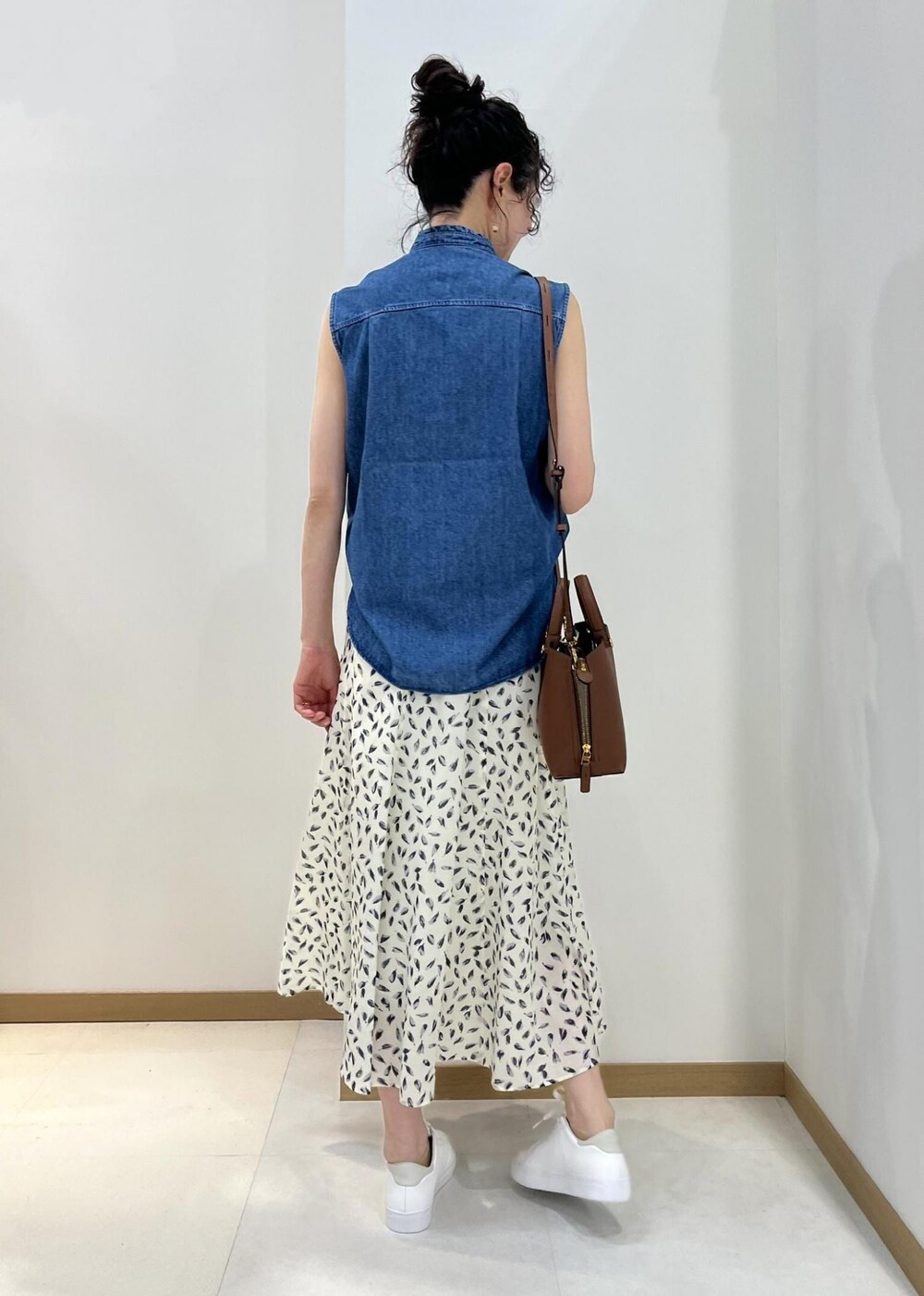 ブラウン系のハンドバッグ、ブルー系のシャツ/ブラウス、ホワイト系のスカートを着用したレディースの春コーディネートの3枚目の写真