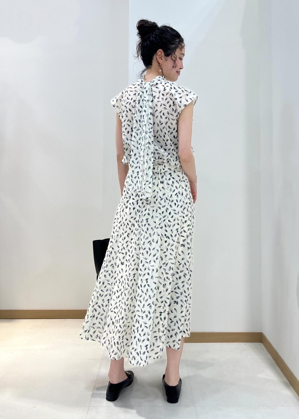 ブラック系のトートバッグ、ブラック系のレインシューズ、ホワイト系のシャツ/ブラウスを着用したレディースの春コーディネートの3枚目の写真