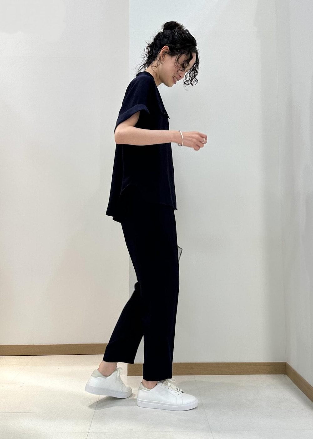 ホワイト系のハンドバッグ、ホワイト系のスニーカー、ブルー系のその他パンツを着用したレディースの夏コーディネートの2枚目の写真