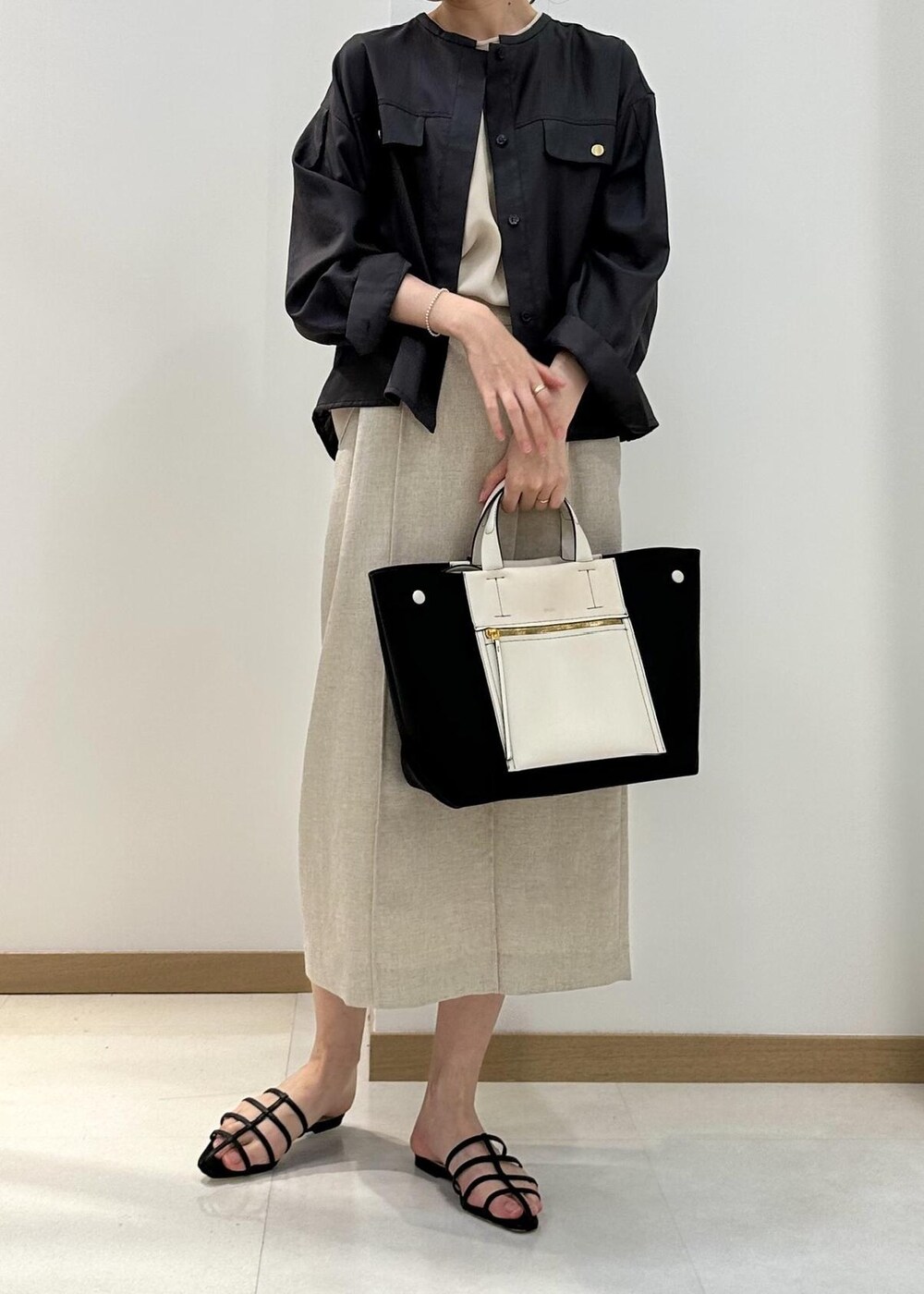 ブラウン系のシャツ/ブラウス、ベージュ系のシャツ/ブラウス、ブラック系のハンドバッグを着用したレディースの夏コーディネートの4枚目の写真