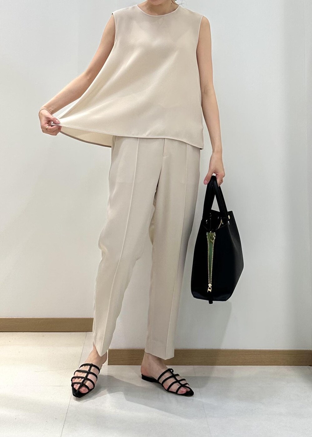 ブラック系のハンドバッグ、ブラック系のサンダル、ベージュ系のシャツ/ブラウスを着用したレディースの夏コーディネートの7枚目の写真