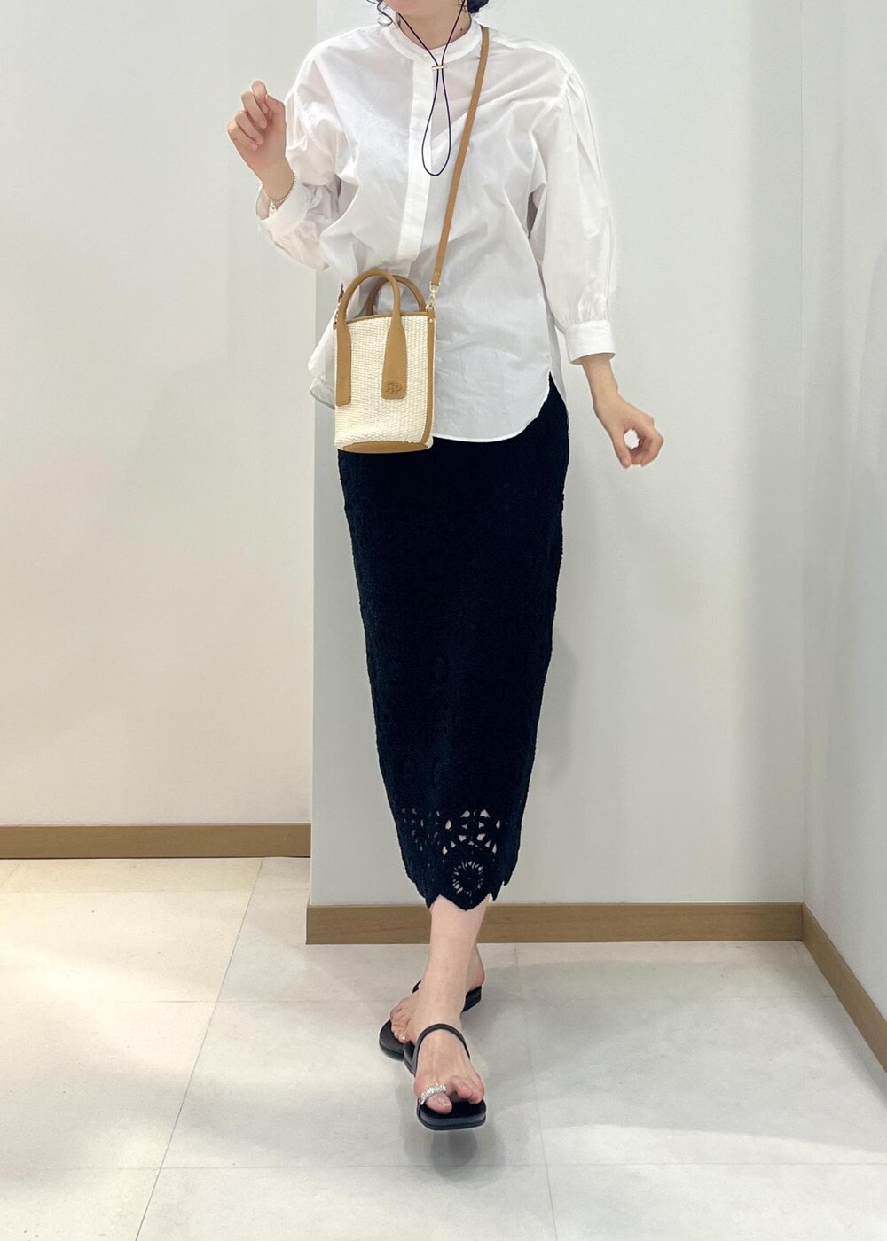 ホワイト系のシャツ/ブラウス、ブラック系のスカート、ベージュ系のハンドバッグを着用したレディースの春コーディネートの4枚目の写真