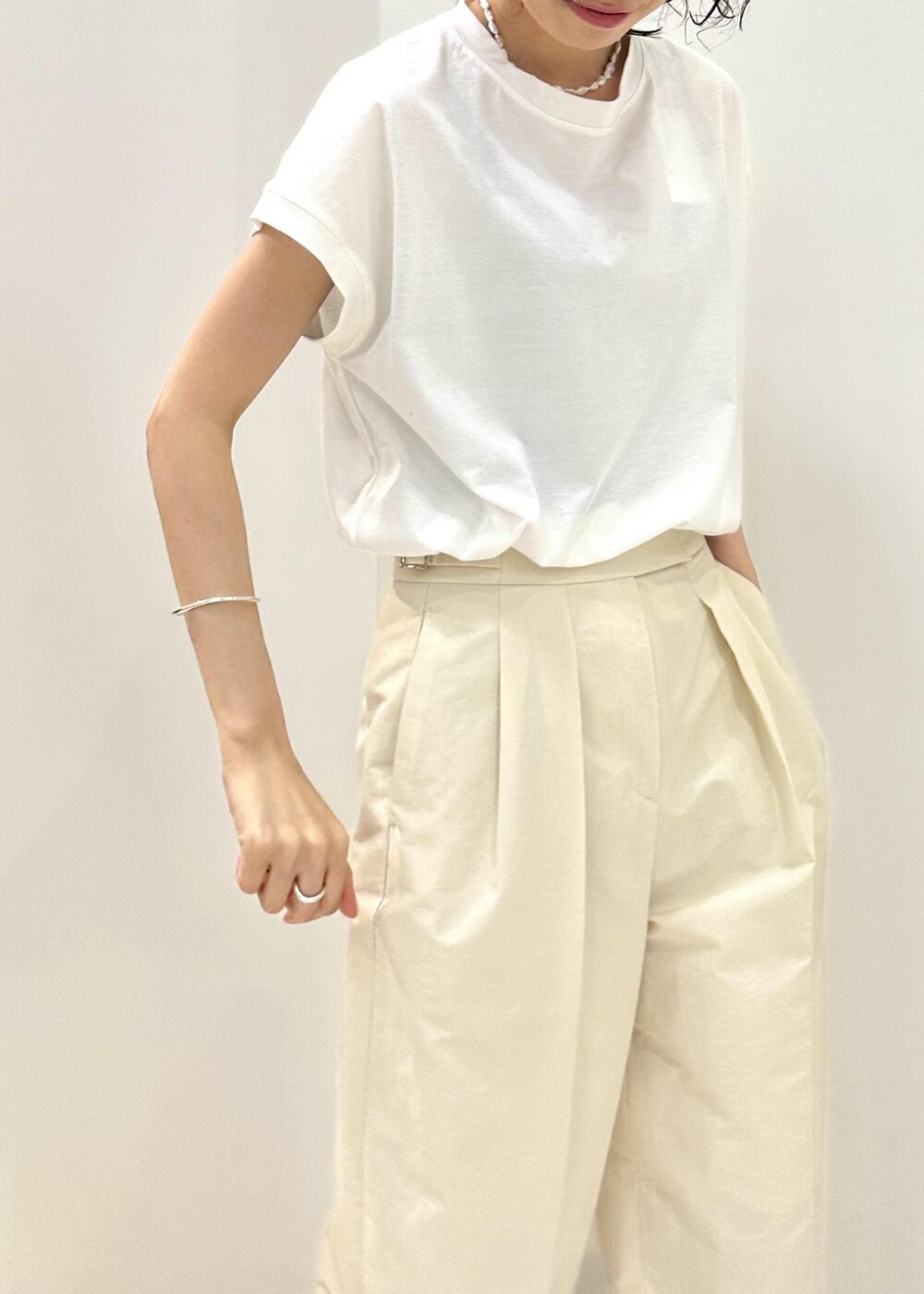 ホワイト系のTシャツ/カットソー、ベージュ系のハンドバッグ、ホワイト系のその他パンツを着用したレディースの夏コーディネートの7枚目の写真