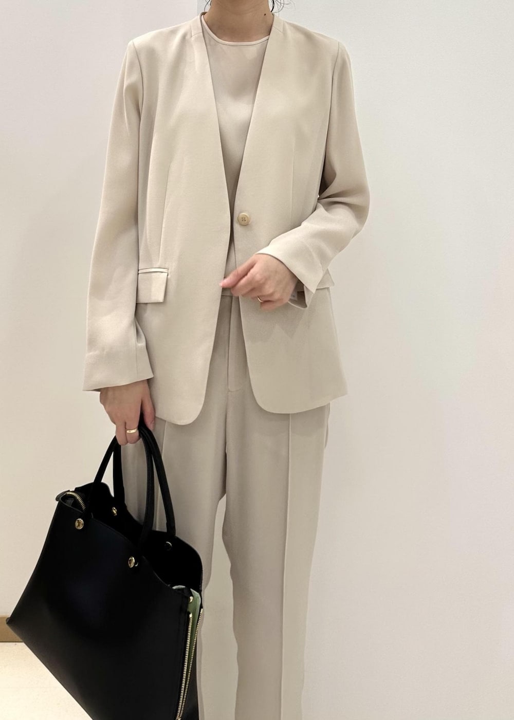 ブラック系のハンドバッグ、ブラック系のサンダル、ベージュ系のシャツ/ブラウスを着用したレディースの夏コーディネートの7枚目の写真