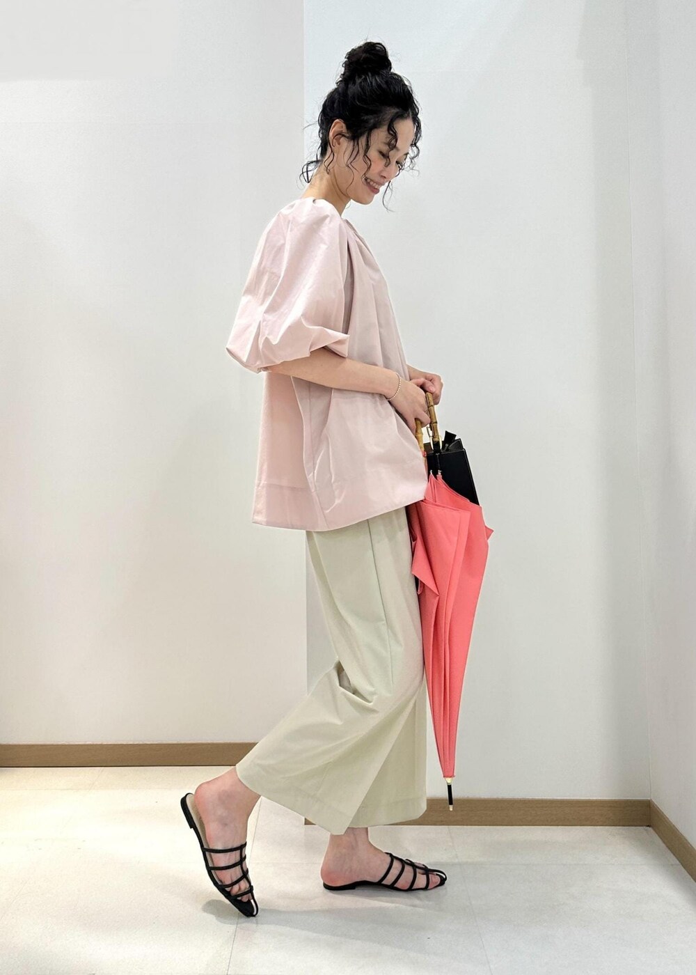 ベージュ系のその他パンツ、ピンク系のシャツ/ブラウス、ブラック系のハンドバッグを着用したレディースの夏コーディネートの3枚目の写真