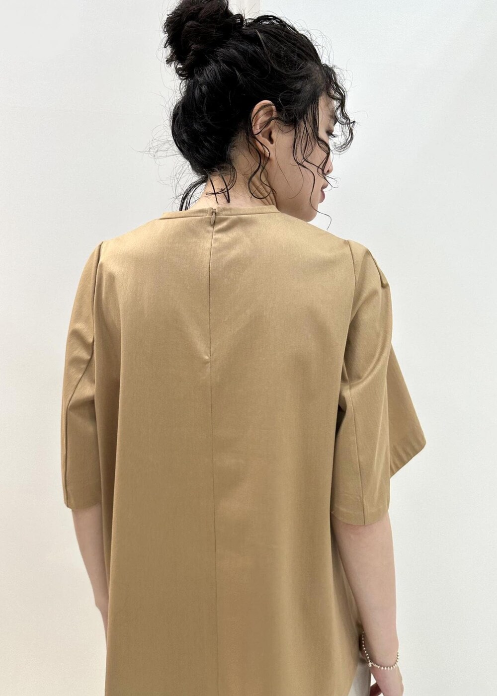 ブラック系のハンドバッグ、ブラック系のサンダル、ベージュ系のTシャツ/カットソーを着用したレディースの夏コーディネートの7枚目の写真