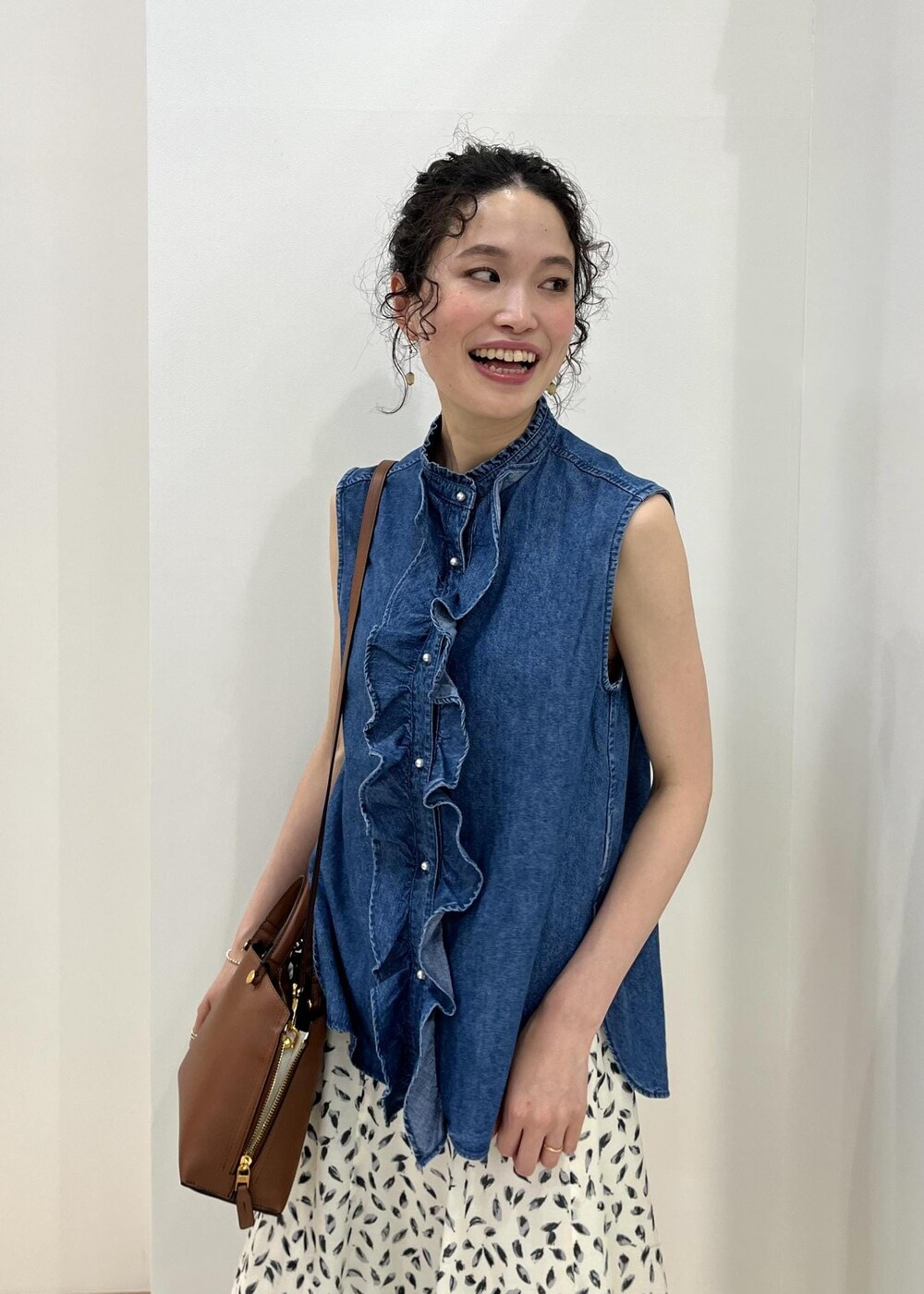 ブラウン系のハンドバッグ、ブルー系のシャツ/ブラウス、ホワイト系のスカートを着用したレディースの春コーディネートの6枚目の写真