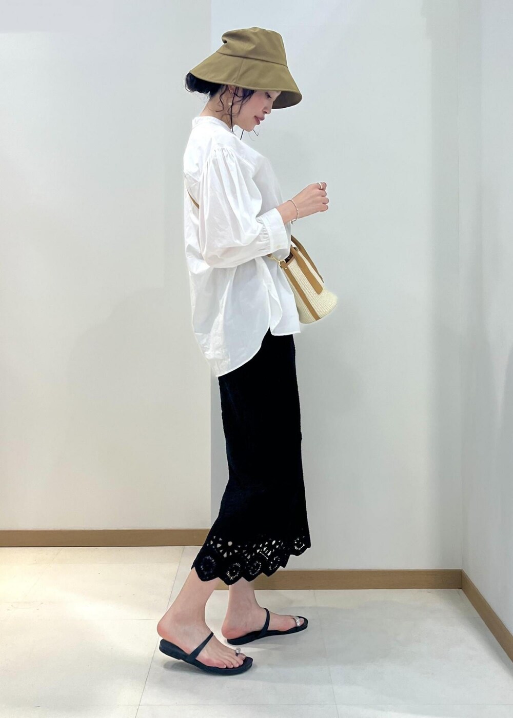 ホワイト系のシャツ/ブラウス、ブラック系のスカート、ベージュ系のハンドバッグを着用したレディースの春コーディネートの2枚目の写真