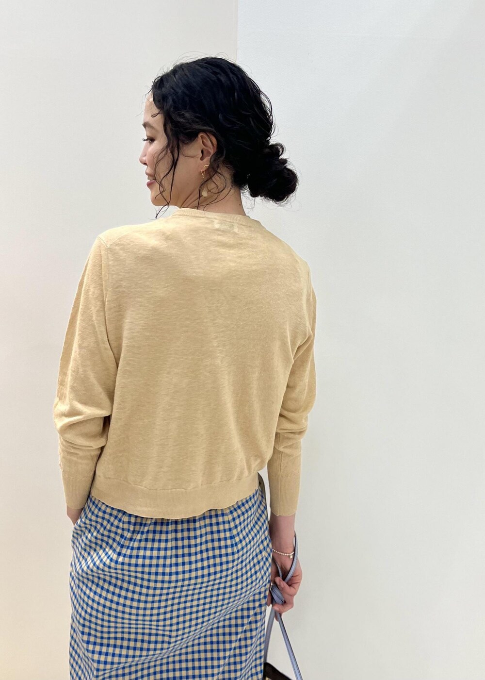 ベージュ系のカーディガン/ボレロ、ブルー系のサンダル、ベージュ系のTシャツ/カットソーを着用したレディースの春コーディネートの6枚目の写真