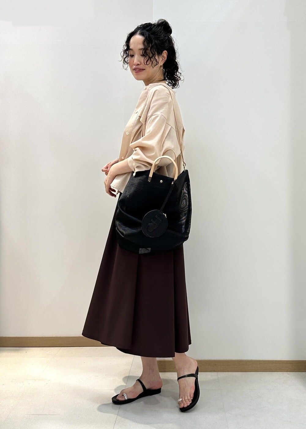 ブラック系のサンダル、ブラック系のトートバッグ、ピンク系のシャツ/ブラウスを着用したレディースの夏コーディネートの2枚目の写真