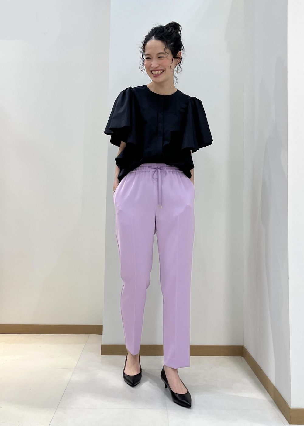 ブラック系のパンプス、ブラック系のトートバッグ、パープル系のその他パンツを着用したレディースの春コーディネートの4枚目の写真