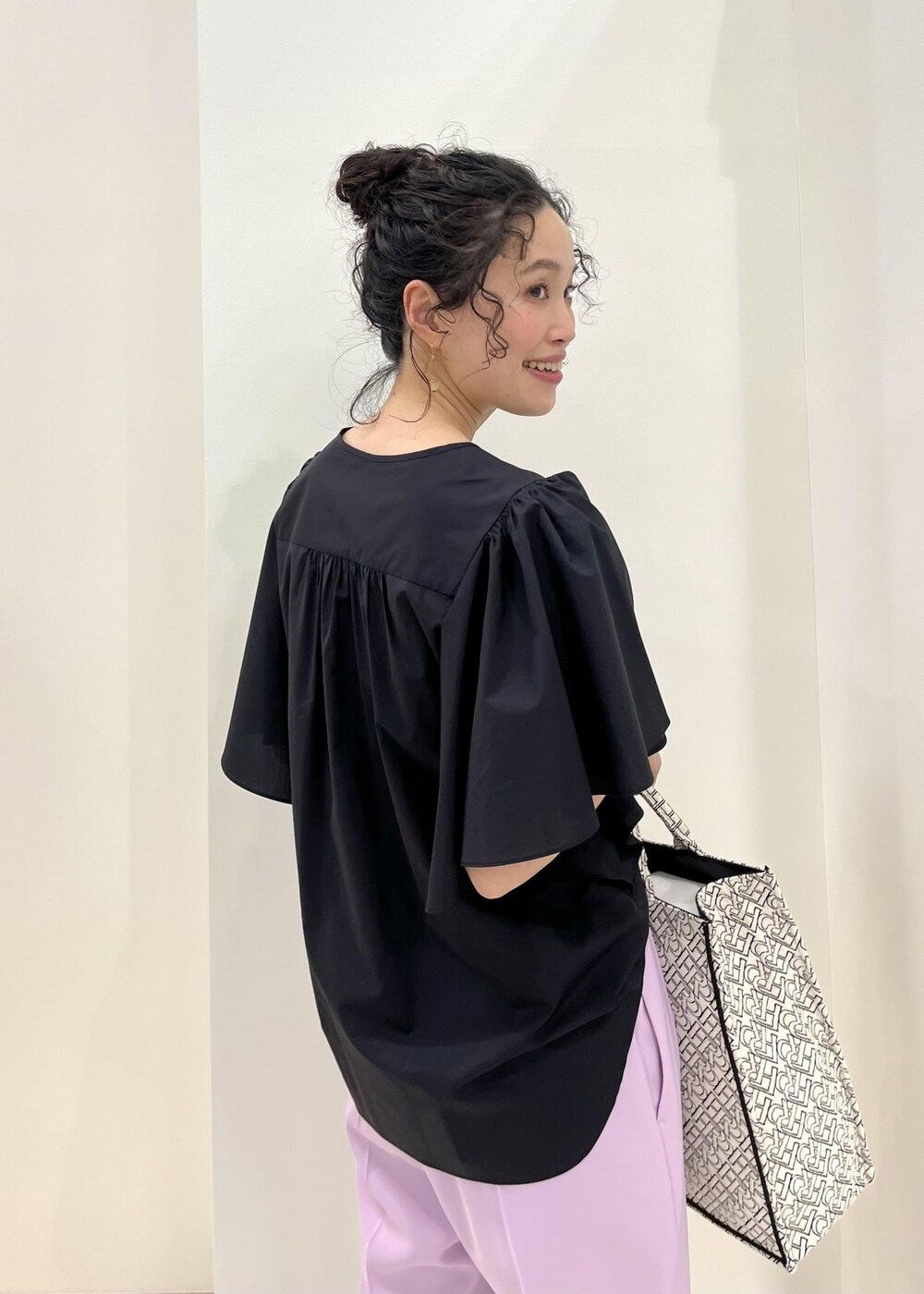 ブラック系のパンプス、ブラック系のトートバッグ、パープル系のその他パンツを着用したレディースの春コーディネートの7枚目の写真