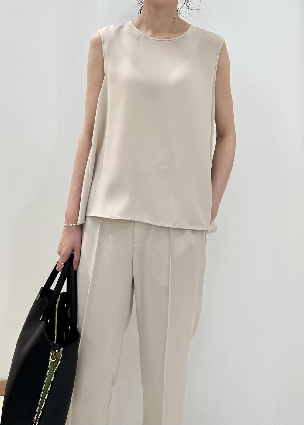 ブラック系のハンドバッグ、ブラック系のサンダル、ベージュ系のシャツ/ブラウスを着用したレディースの夏コーディネートの8枚目の写真