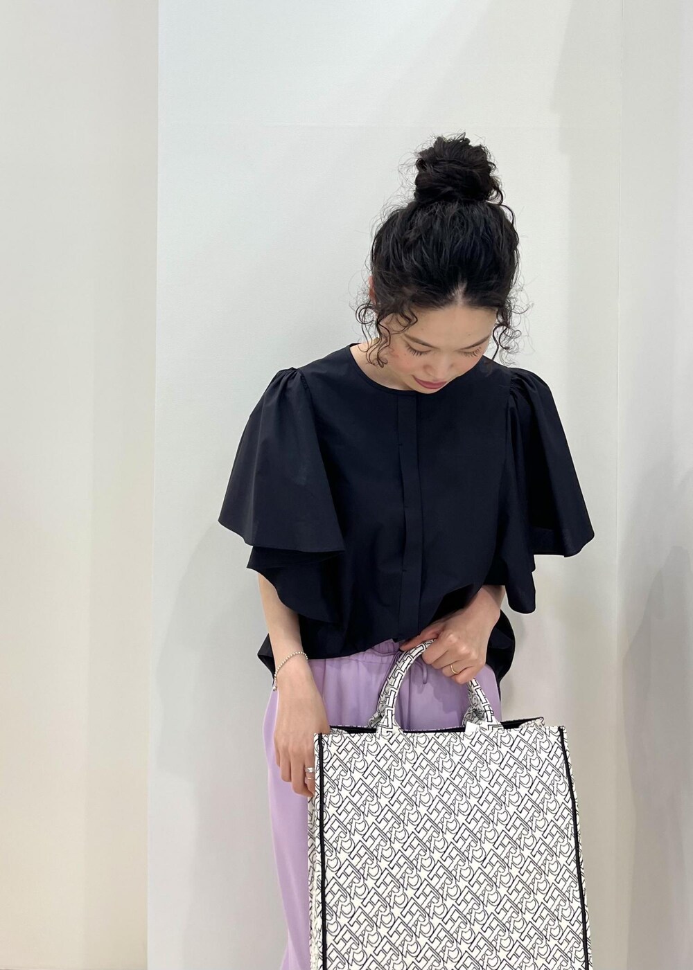 ブラック系のパンプス、ブラック系のトートバッグ、パープル系のその他パンツを着用したレディースの春コーディネートの6枚目の写真