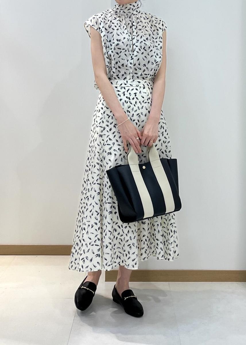 ブラック系のトートバッグ、ブラック系のレインシューズ、ホワイト系のシャツ/ブラウスを着用したレディースの春コーディネートの4枚目の写真