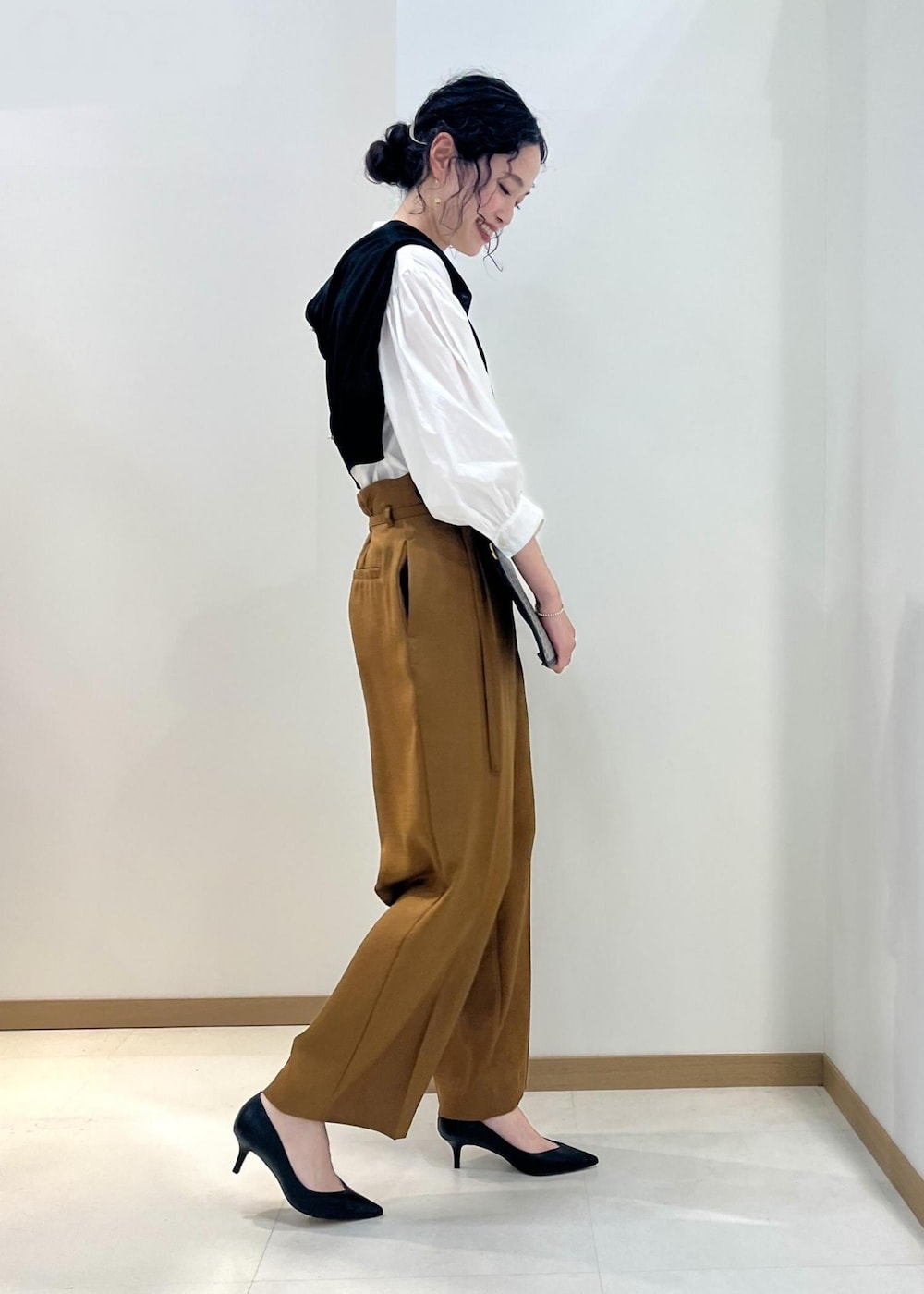 ブラック系のパンプス、ホワイト系のシャツ/ブラウス、ブラック系のカーディガン/ボレロを着用したレディースの春コーディネートの2枚目の写真