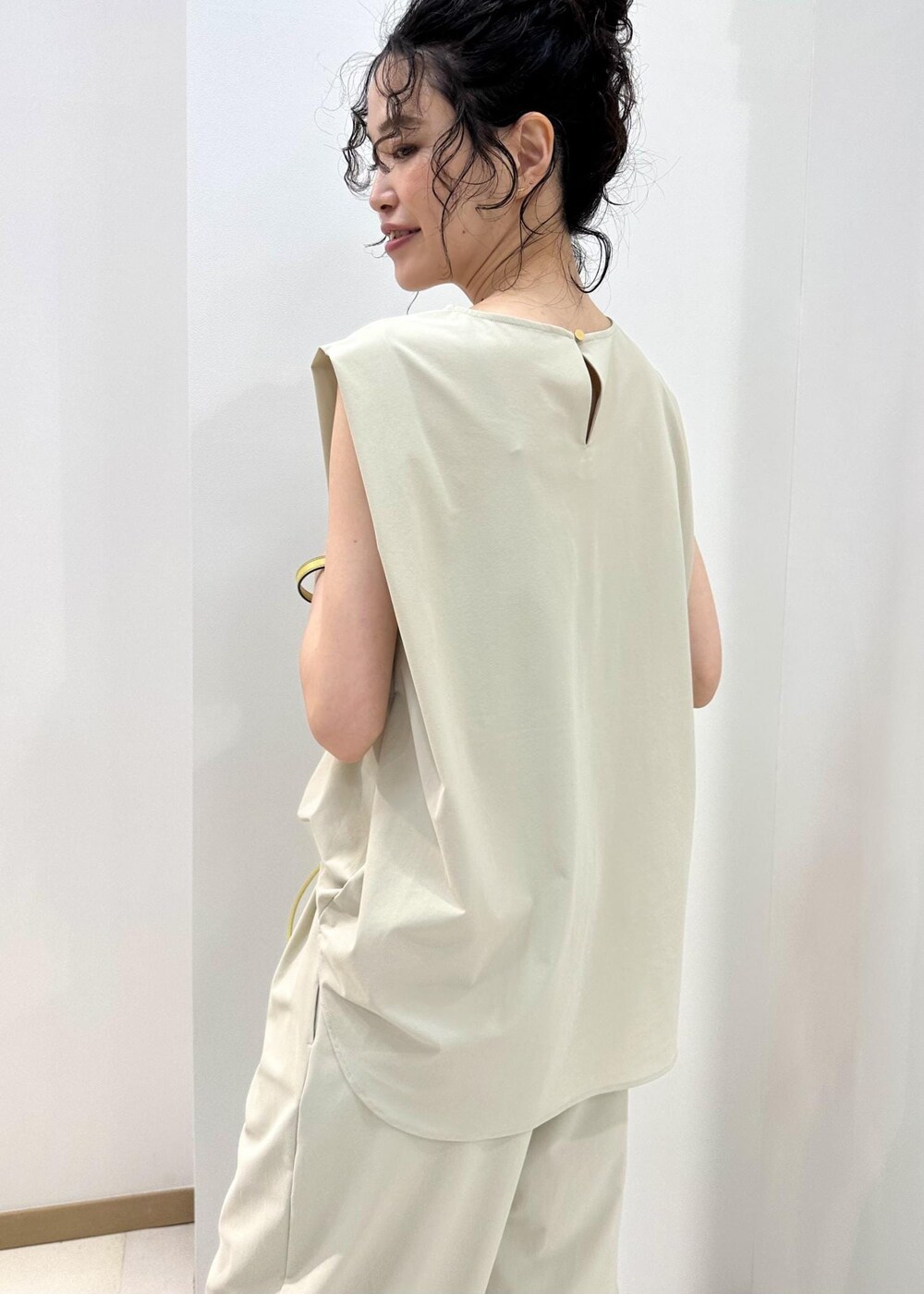 ブラック系のサンダル、ベージュ系のハンドバッグ、ベージュ系のシャツ/ブラウスを着用したレディースの夏コーディネートの7枚目の写真