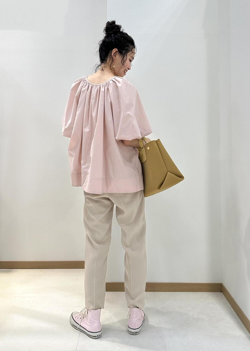 イエロー系のハンドバッグ、ベージュ系のその他パンツ、ピンク系のシャツ/ブラウスを着用したレディースの夏コーディネートの3枚目の写真