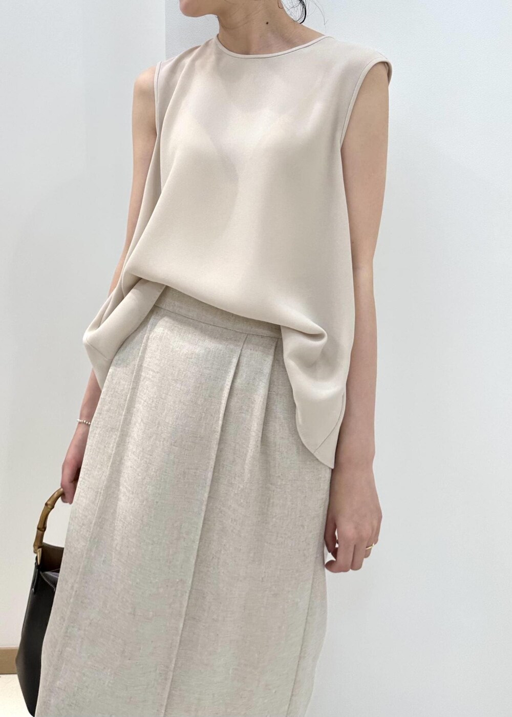 ブラウン系のシャツ/ブラウス、ベージュ系のシャツ/ブラウス、ブラック系のハンドバッグを着用したレディースの夏コーディネートの7枚目の写真