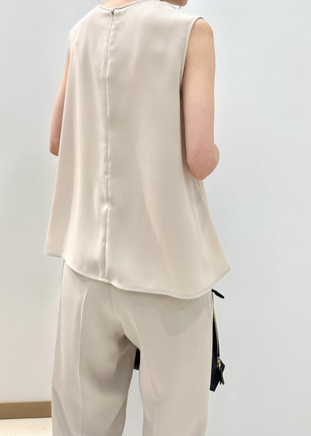 ブラック系のハンドバッグ、ブラック系のサンダル、ベージュ系のシャツ/ブラウスを着用したレディースの夏コーディネートの6枚目の写真