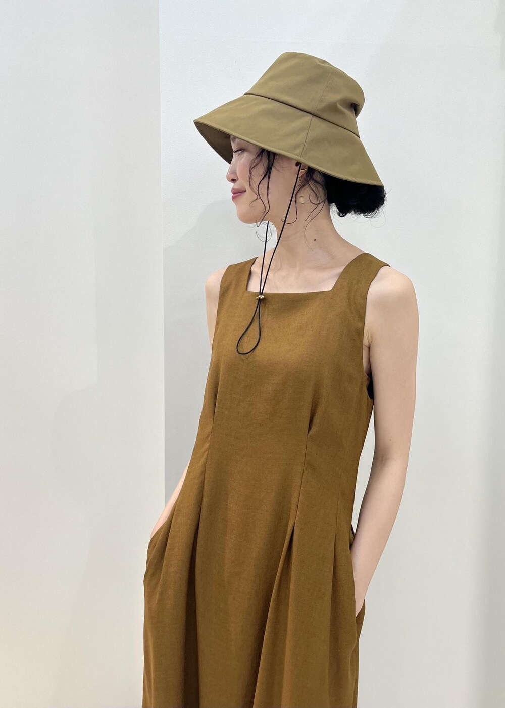 ブラック系のハンドバッグ、ブラック系のサンダル、オレンジ系のカーディガン/ボレロを着用したレディースの夏コーディネートの5枚目の写真