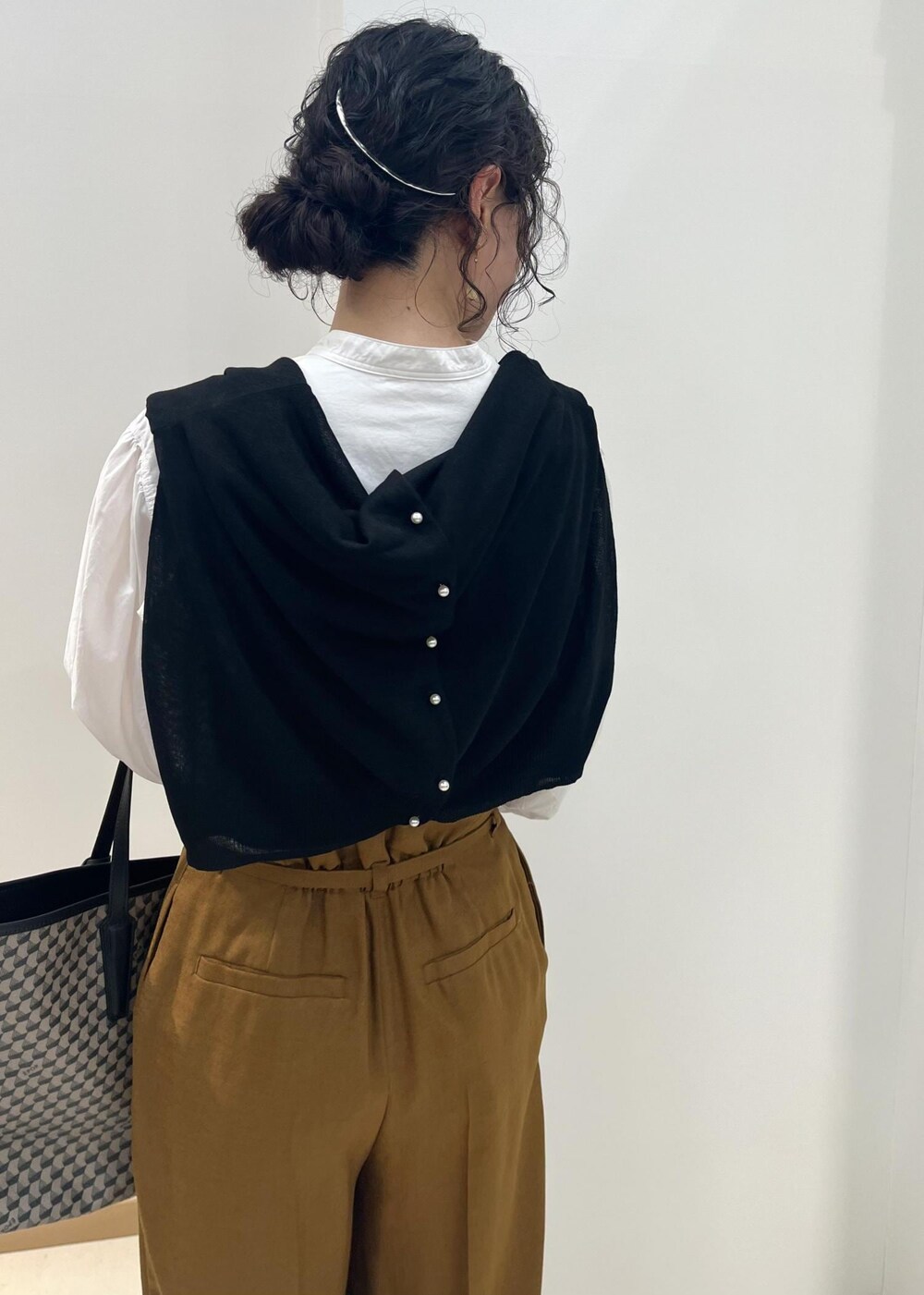 ブラック系のパンプス、ホワイト系のシャツ/ブラウス、ブラック系のカーディガン/ボレロを着用したレディースの春コーディネートの6枚目の写真