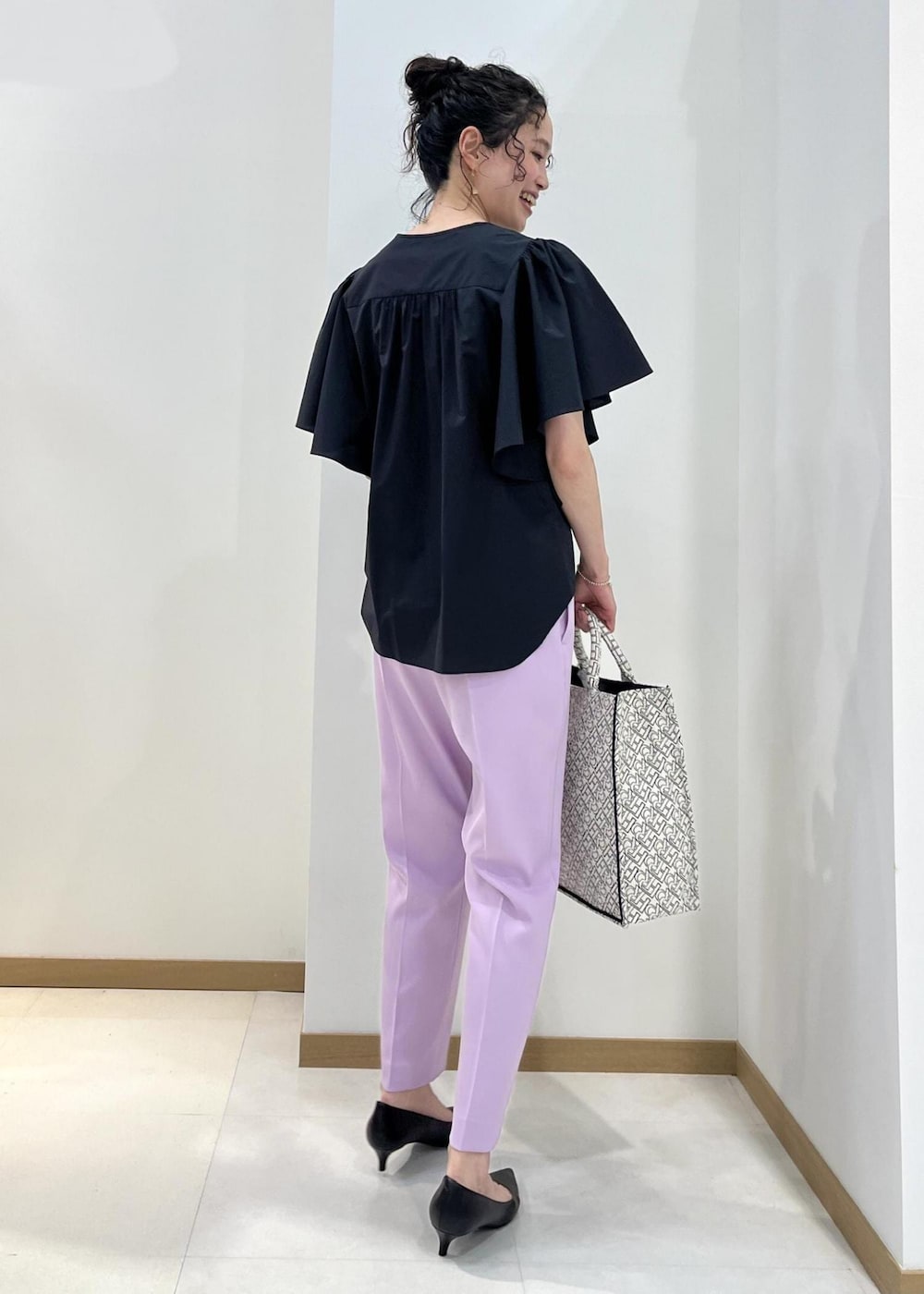 ブラック系のパンプス、ブラック系のトートバッグ、パープル系のその他パンツを着用したレディースの春コーディネートの3枚目の写真