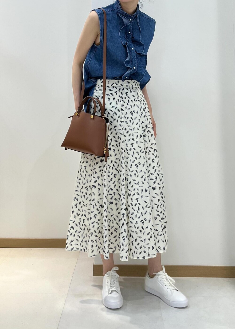 ブラウン系のハンドバッグ、ブルー系のシャツ/ブラウス、ホワイト系のスカートを着用したレディースの春コーディネートの4枚目の写真