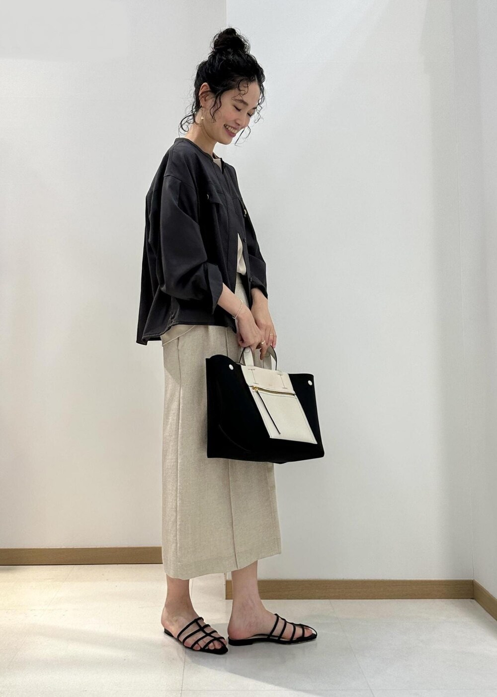 ブラウン系のシャツ/ブラウス、ベージュ系のシャツ/ブラウス、ブラック系のハンドバッグを着用したレディースの夏コーディネートの2枚目の写真