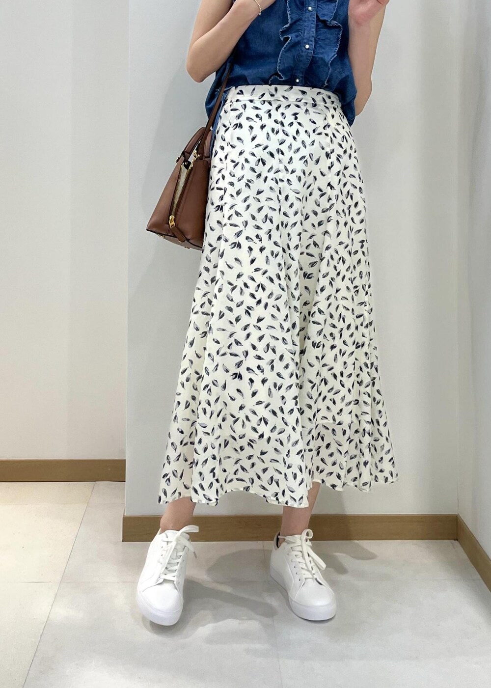 ブラウン系のハンドバッグ、ブルー系のシャツ/ブラウス、ホワイト系のスカートを着用したレディースの春コーディネートの5枚目の写真